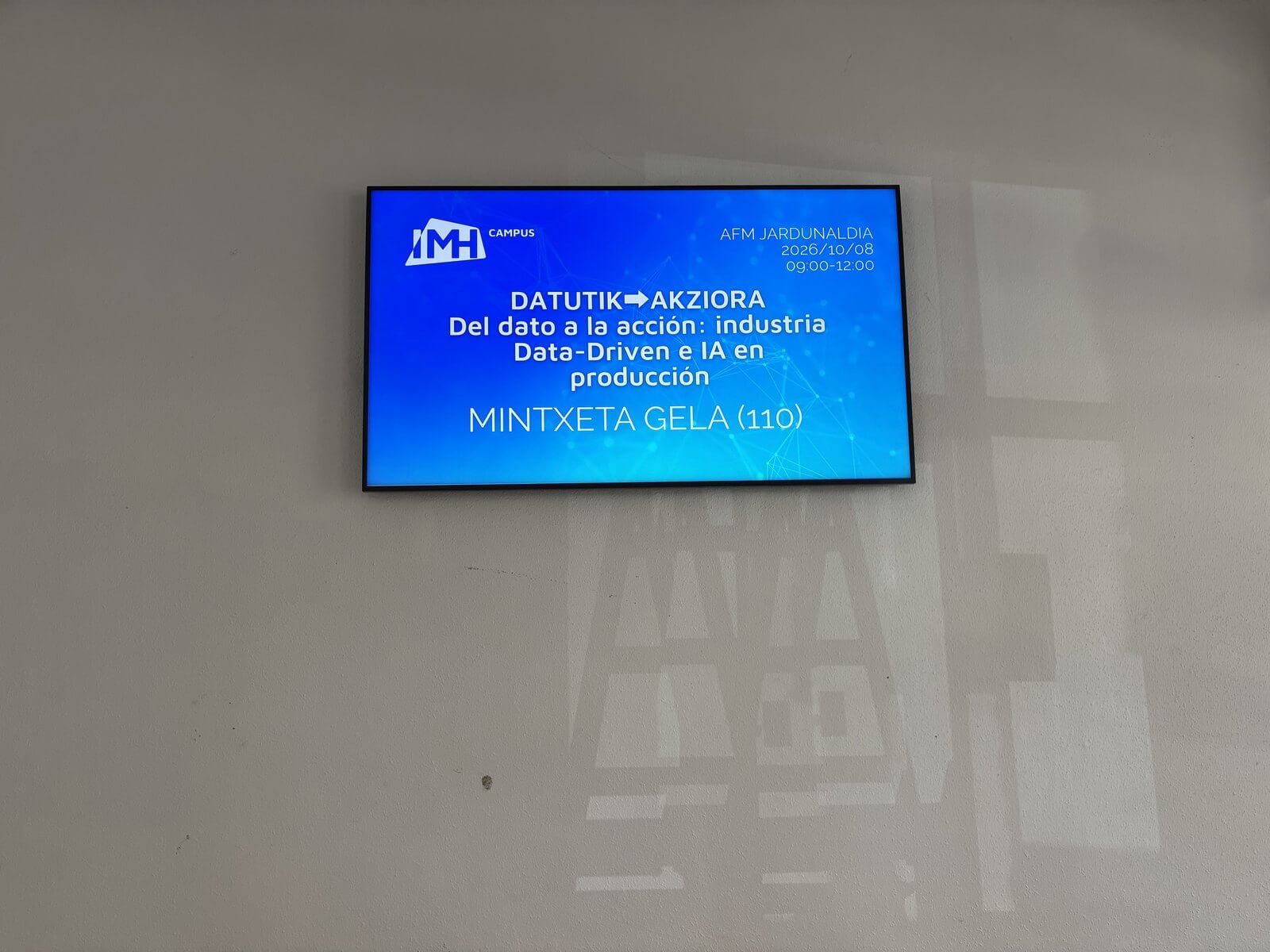 Pantalla del IMH Campus anunciando la jornada AFM Datutik Akziora, Del dato a la acción, en la sala Mintxeta el 8 de octubre de 2026